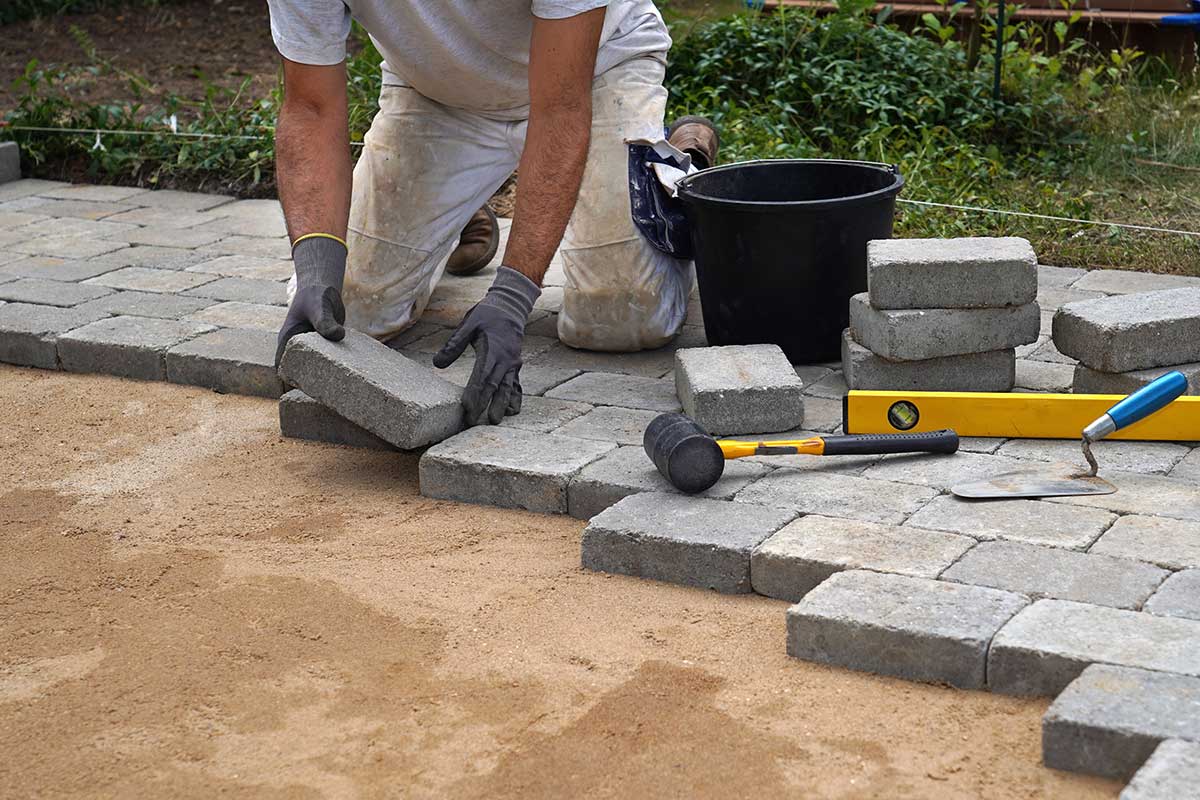 man laying pavers for a patio