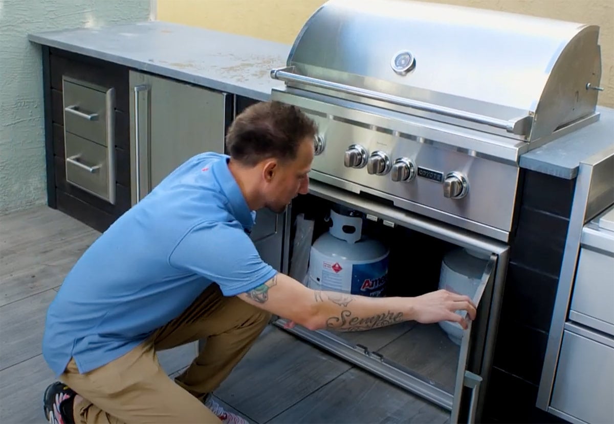 man opening double access doors in rta outdoor kitchen