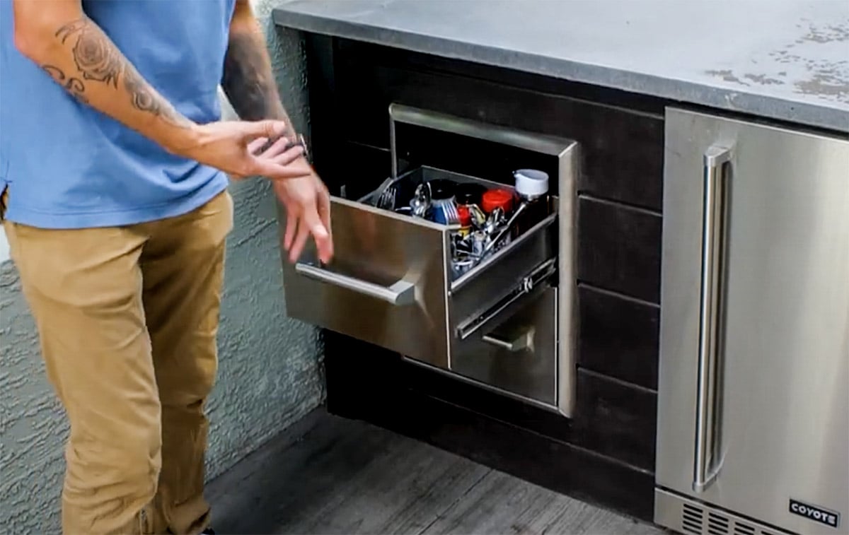 man opening outdoor kitchen drawer
