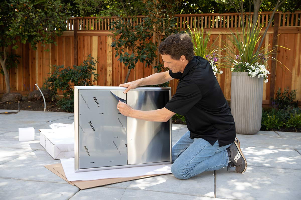 man removing protective sticker from storage doors