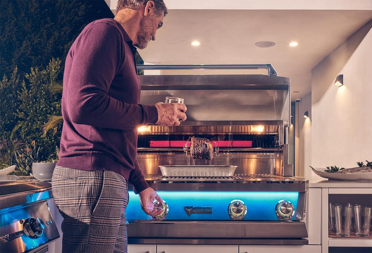 man using twin eagles grill on patio