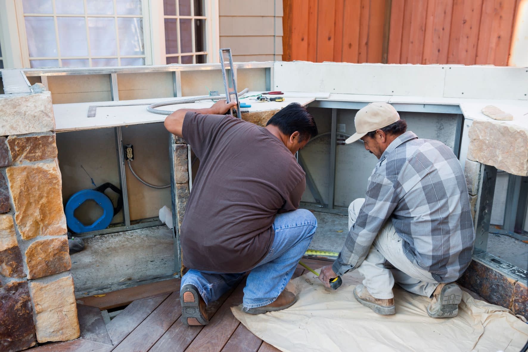 Two Homeowners Working on a DIY Frame Outdoor Kitchen Project Doing Appliance Cut Outs