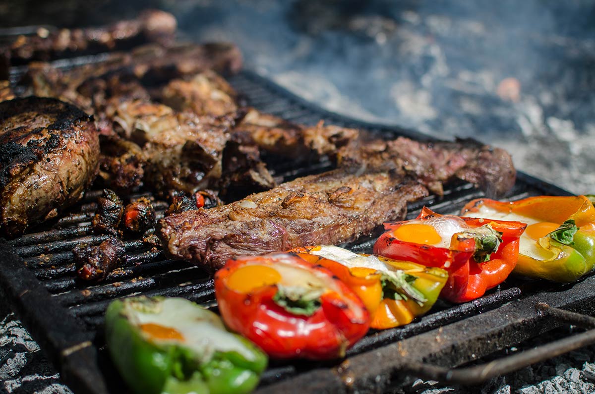 meat and peppers being grilled on Argentinian grill