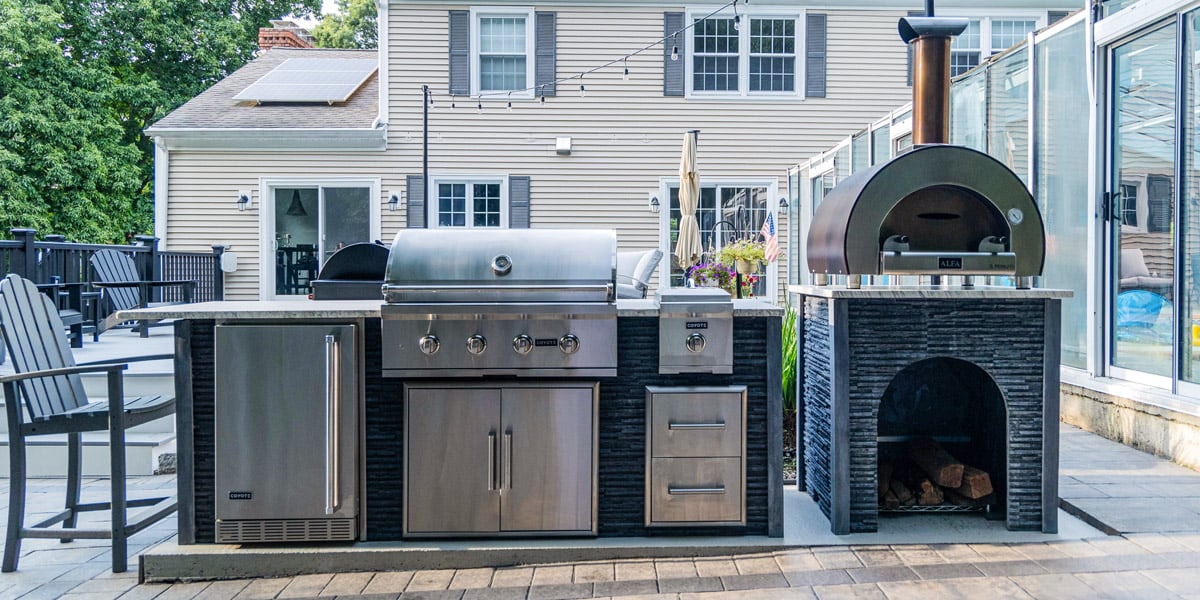 mini outdoor kitchen with side burner fridge and storage drawers with separate pizza oven stand