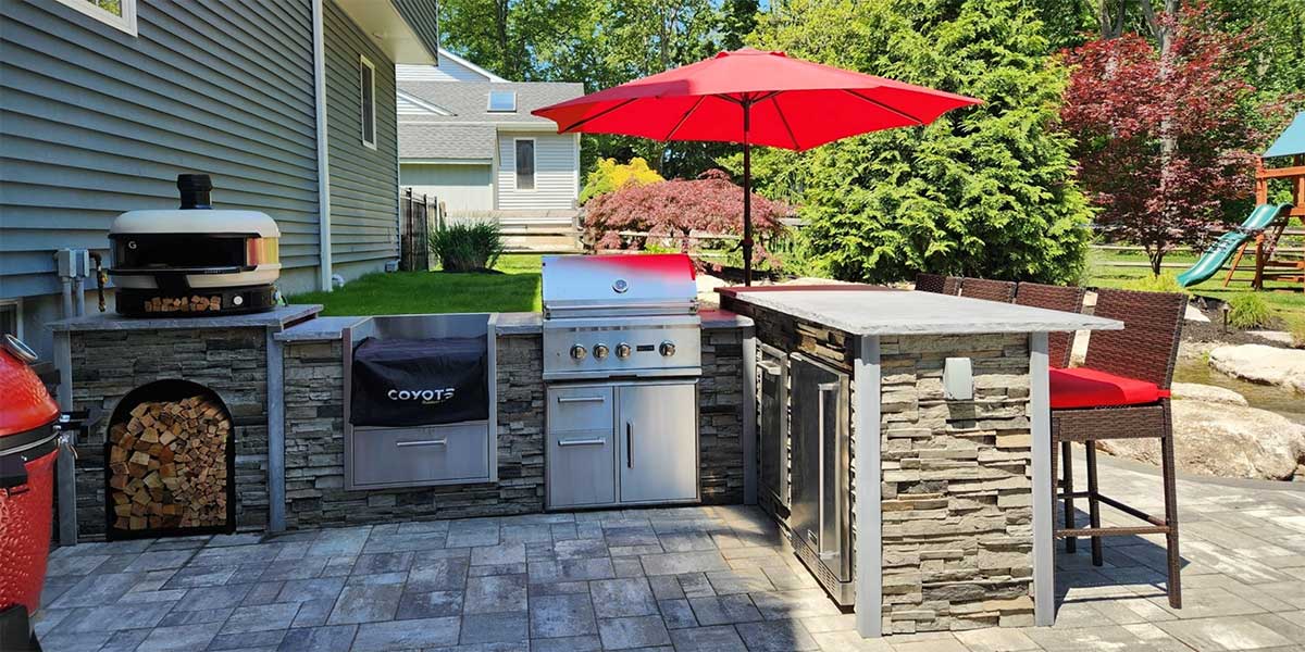 modern l shape outdoor kitchen with bar seating and umbrella