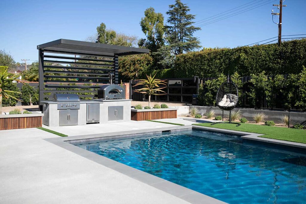 modern linear outdoor kitchen with pizza oven by pool