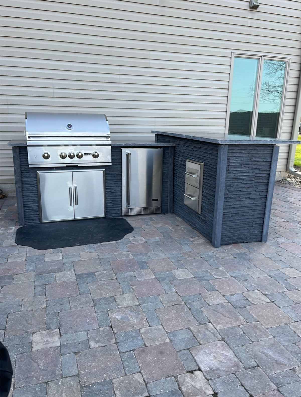 modern stone outdoor kitchen with bar top with grill