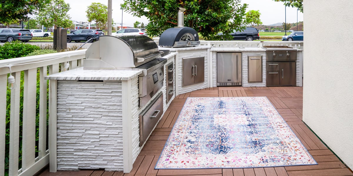 modern stone outdoor kitchen on wraparound patio