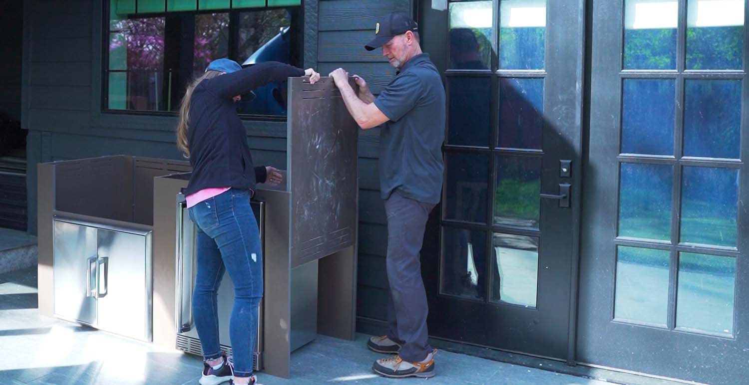 Two friends assembling an RTA MOKS Modular Outdoor Kitchen in a Backyard