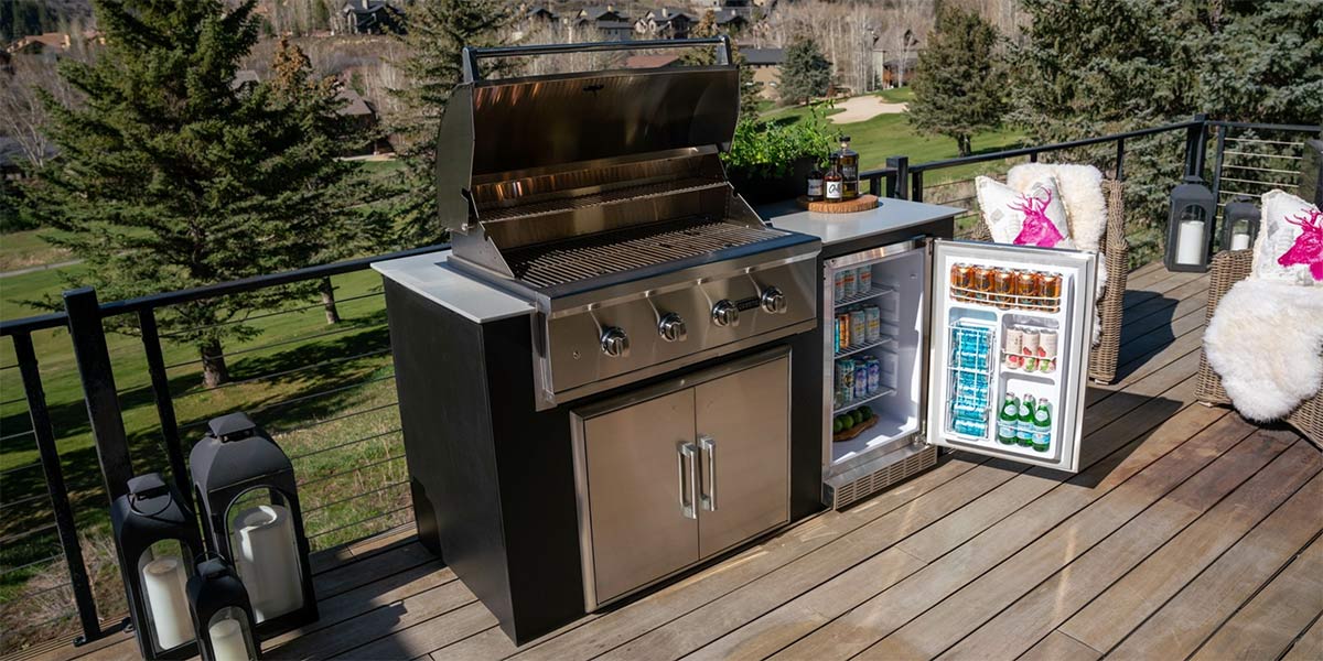 modular outdoor kitchen with opened grill hood and refrigerator door