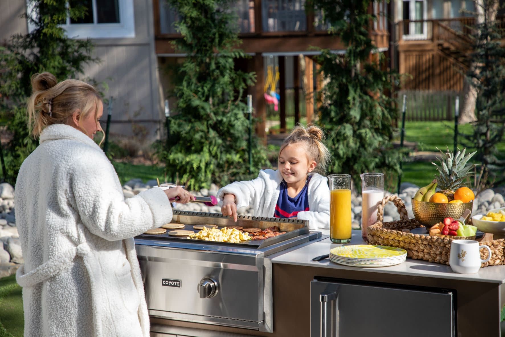 Mom Cooking Breakfast on a Flattop Grill with Daughter in Their Outdoor Space