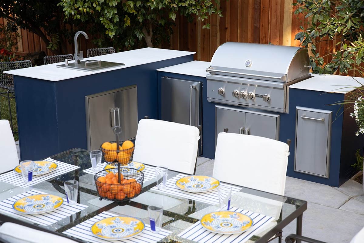 moks l shaped outdoor kitchen with bar seating and additional seating at dining table