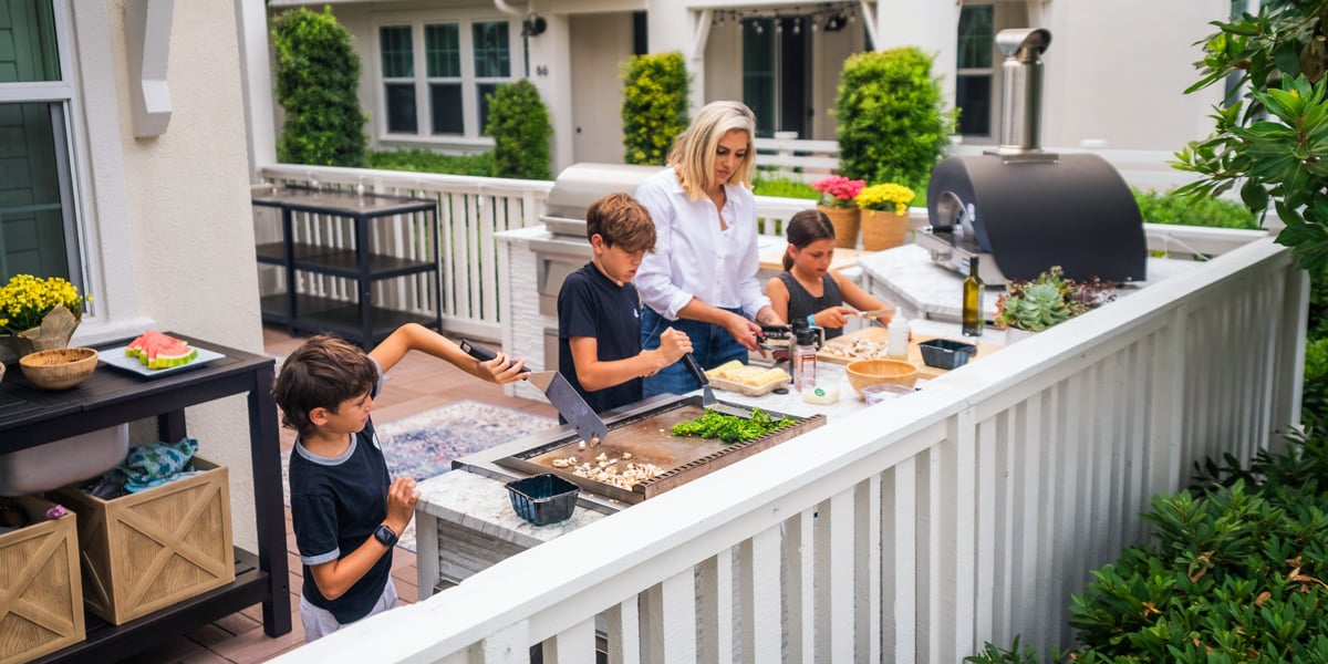 mom cooking with 3 kids at her outdoor kitchend