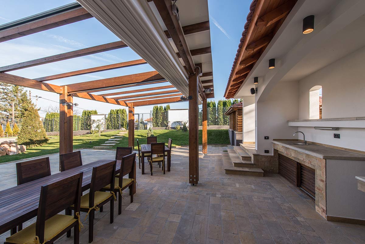 Motorized retractable fabric cover for a pergola
