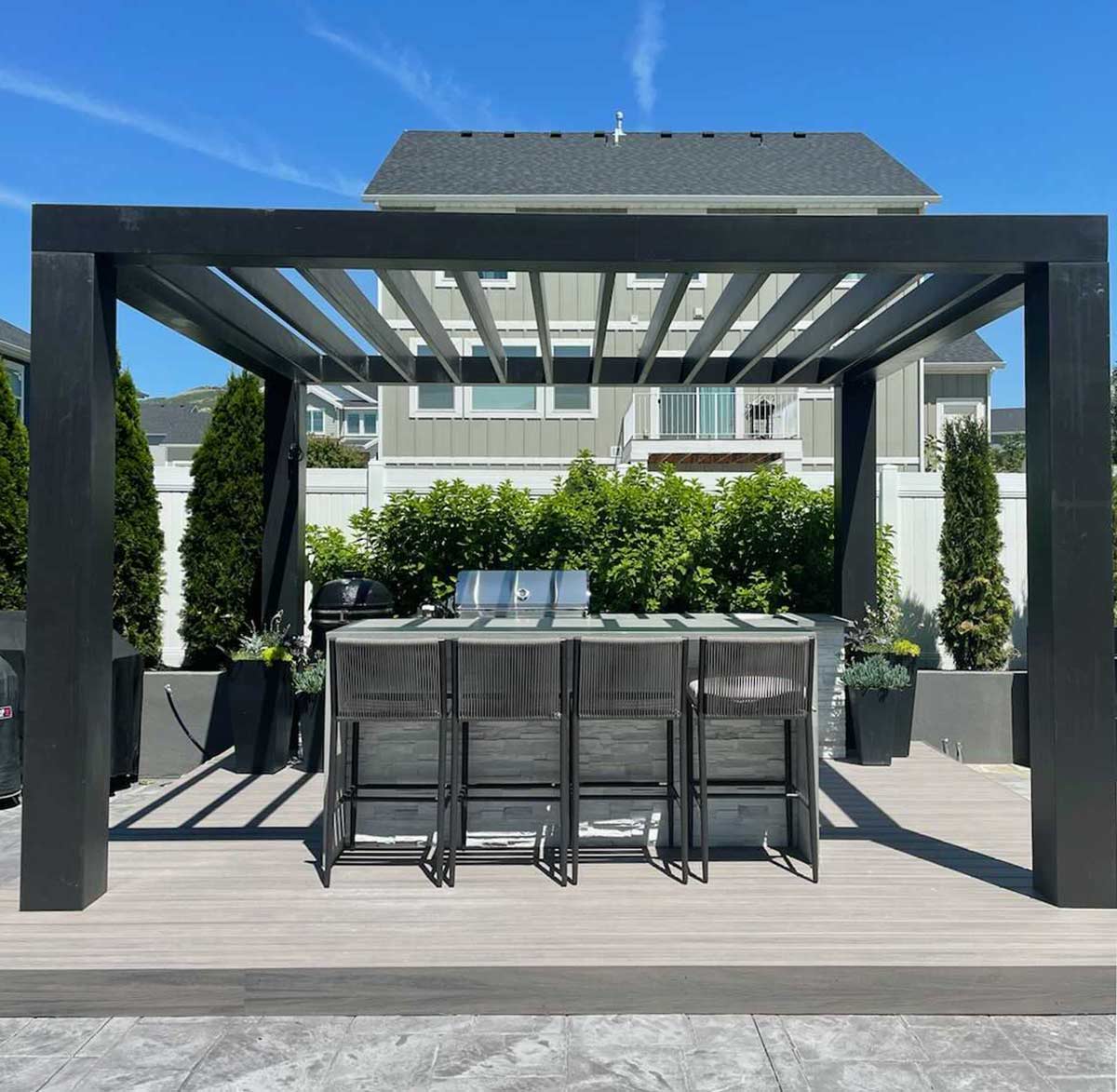 modern outdoor kitchen pergola over outdoor bar seating at outdoor kitchen