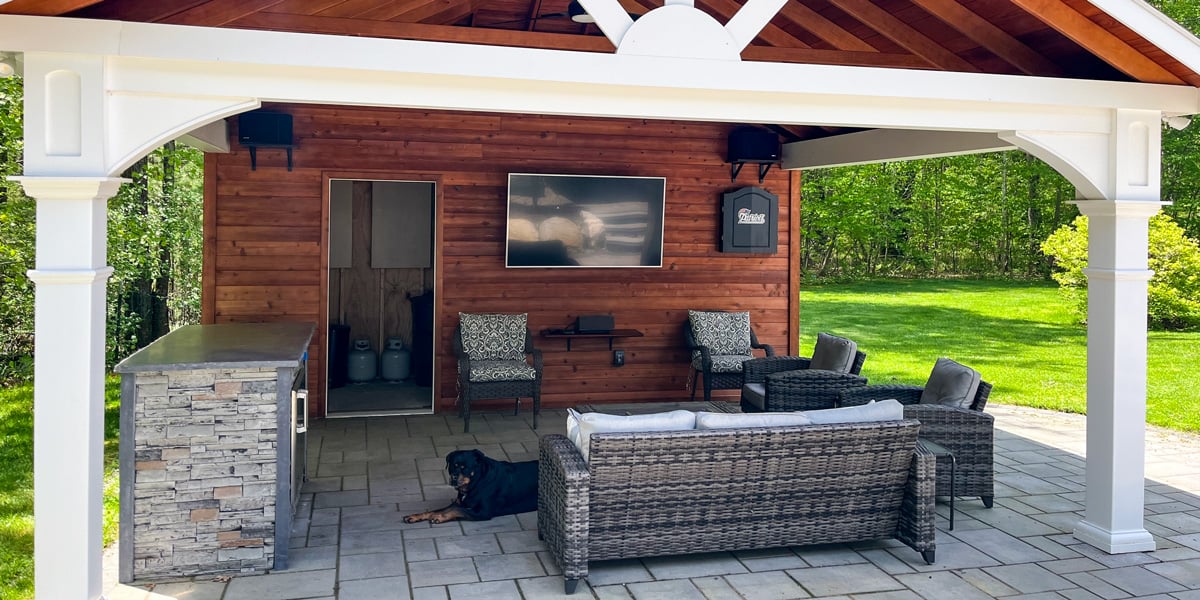 outdoor covered kitchen idea with tv and seating area