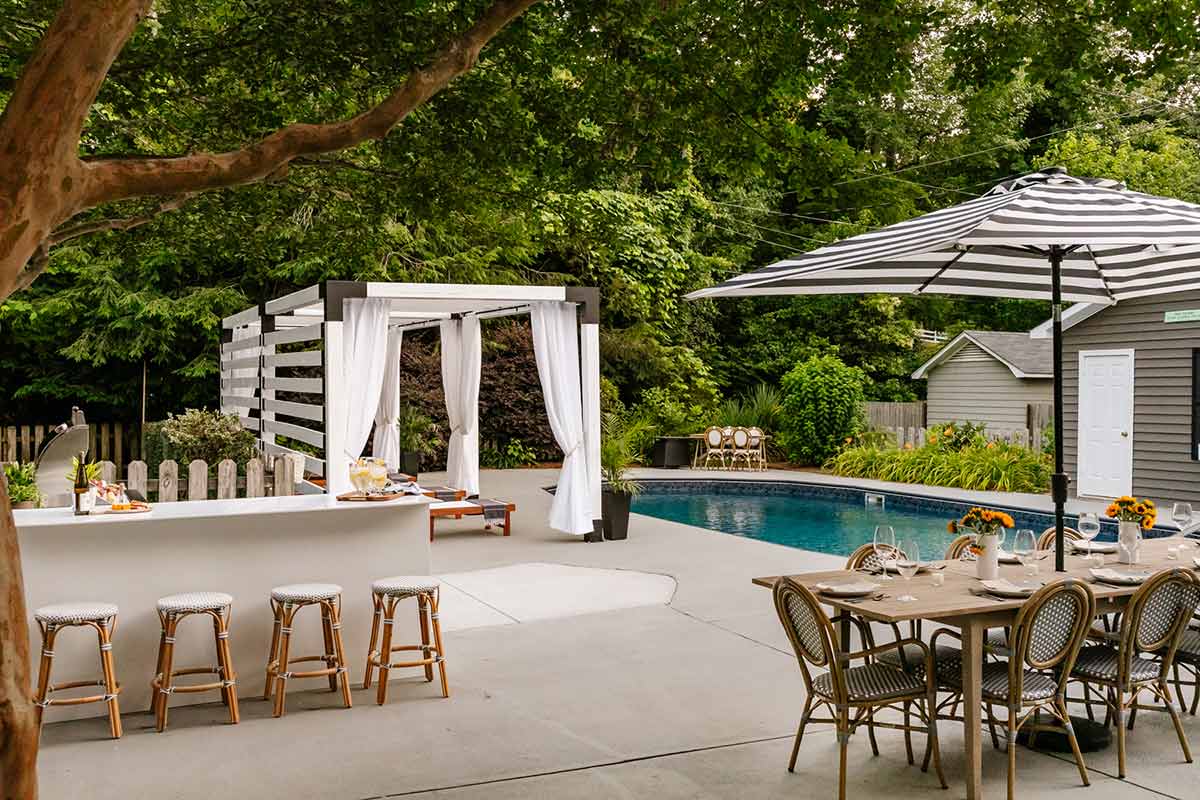outdoor kitchen bar seating on patio by pool