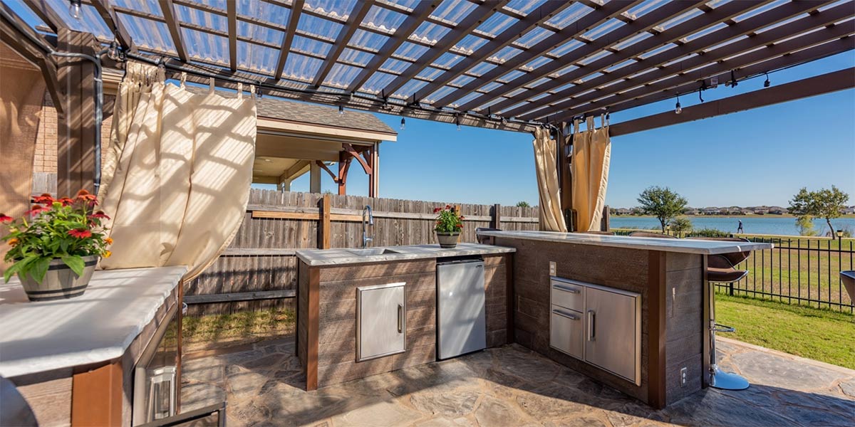 outdoor kitchen bar with weathered wood style finish and pergola
