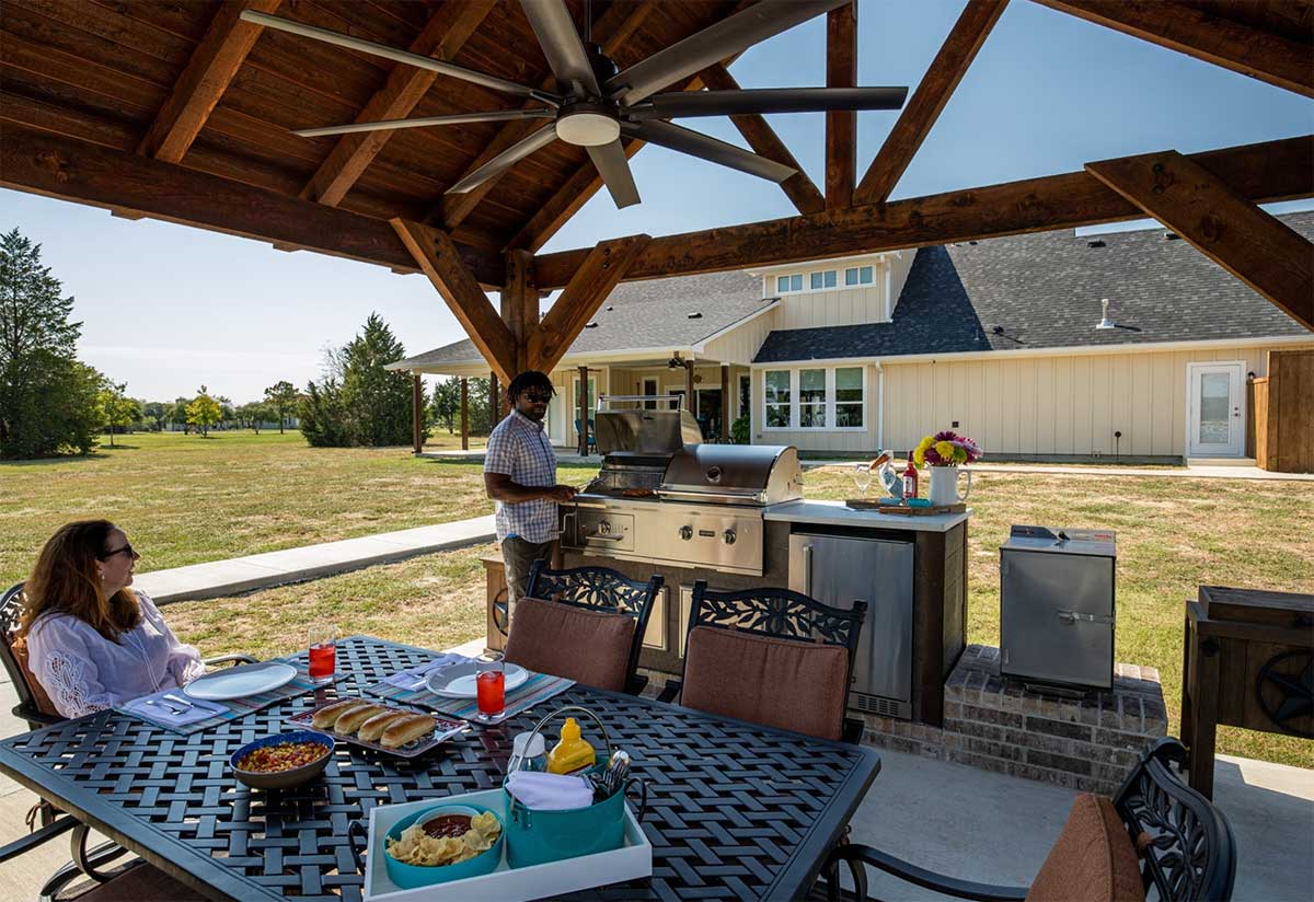 outdoor kitchen on patio under a pergola with weathered wood umber finish in texas