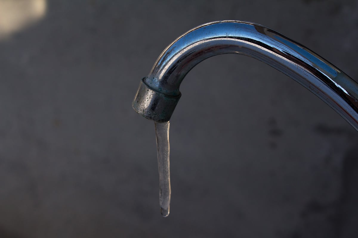 outdoor kitchen sink with frozen water coming out of spout