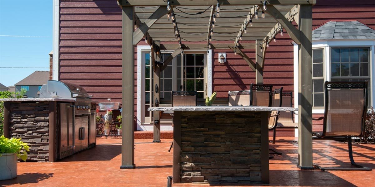 outdoor kitchen under pergola on patio with earthy colors