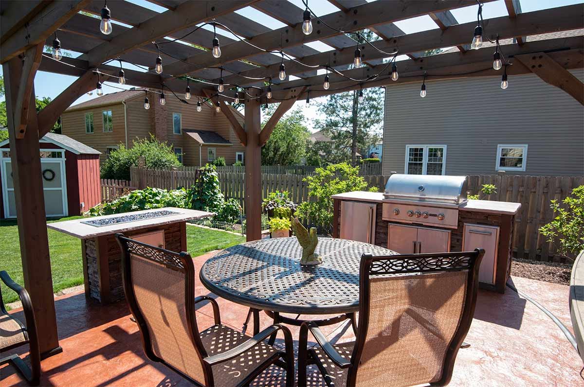 outdoor kitchen under pergola with string lights