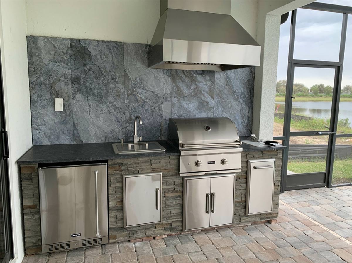 outdoor kitchen with backsplash and vent hood