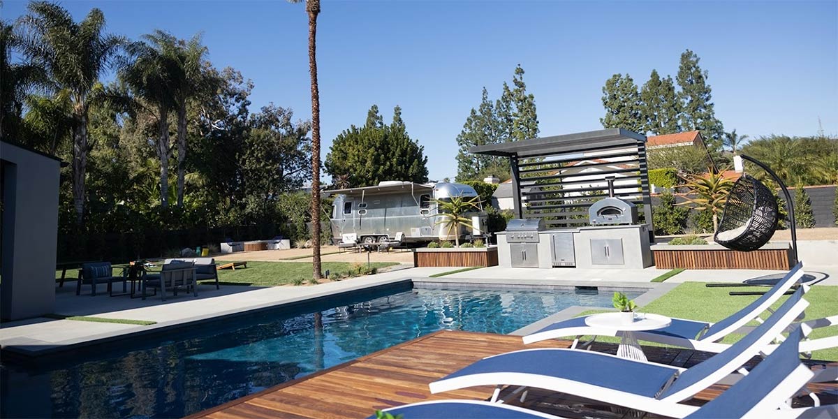outdoor kitchen with pool and lounge area