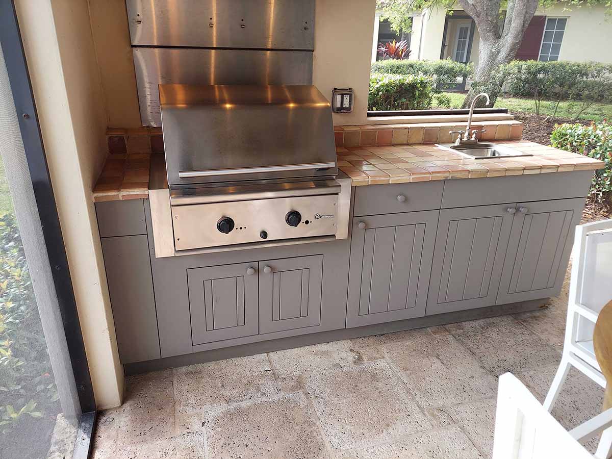 outdoor kitchen with tile countertop and built in grill