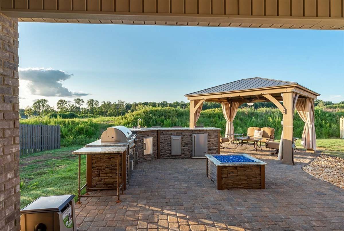 outdoor living space with large wooden outdoor pavilion next to an outdoor kitchen