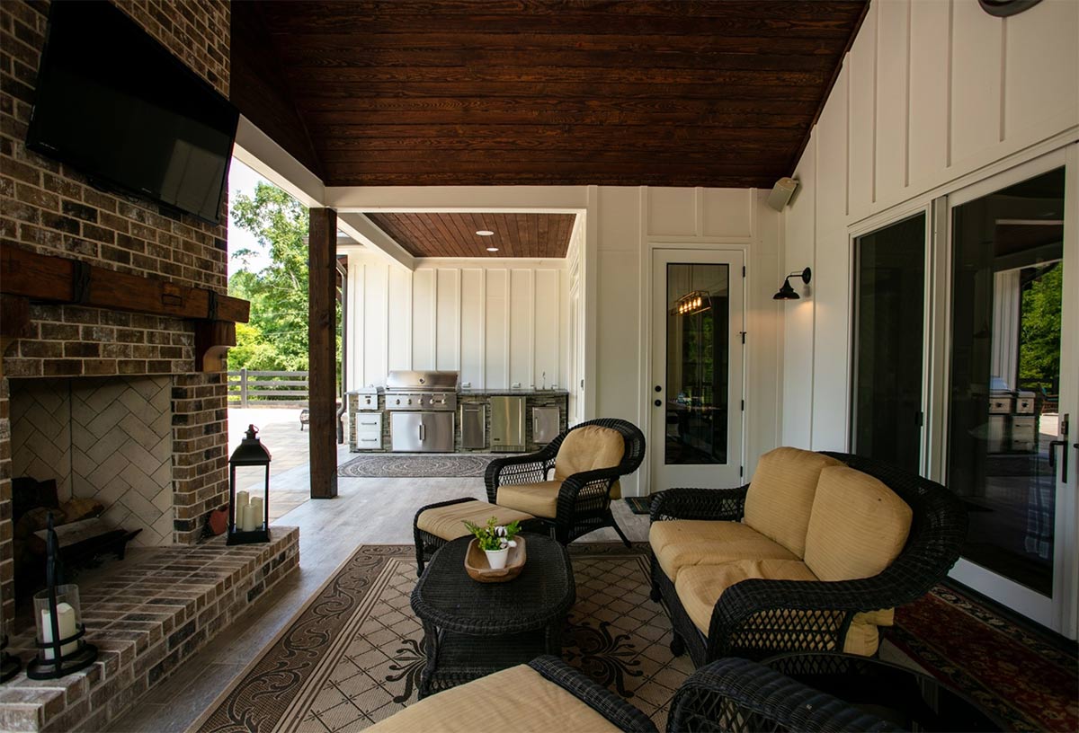 outdoor seating area next to outdoor kitchen with outdoor tv