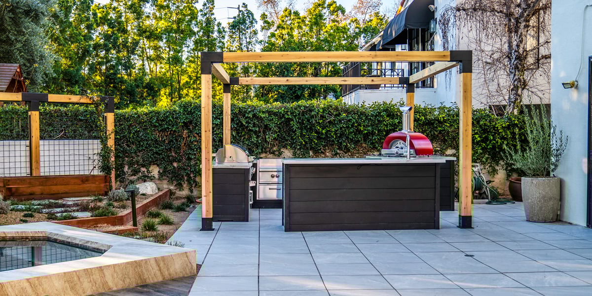 paver patio backyard with hot tub and outdoor kitchen
