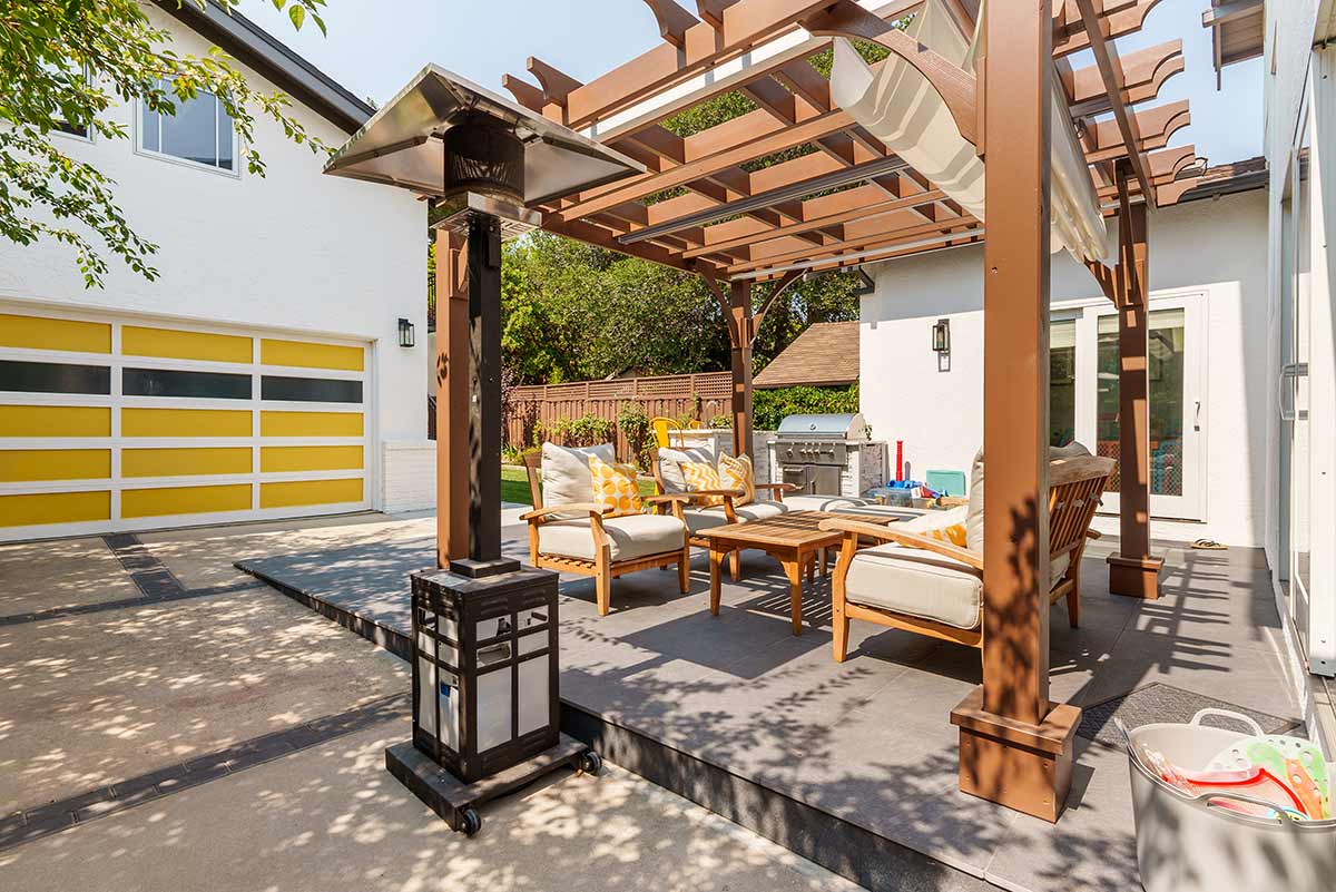 pergola with seating area and garage with yellow doors outdoor space