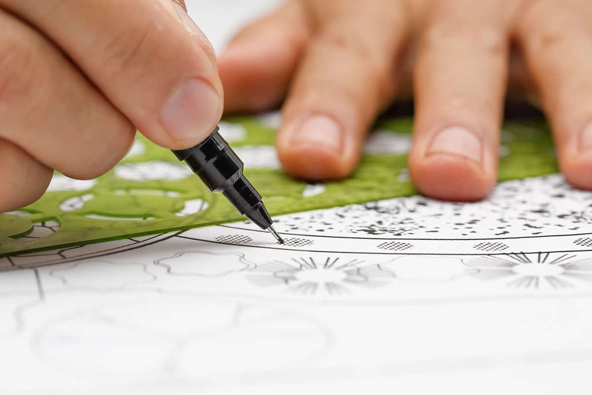 person hand drawing blueprint for an outdoor kitchen in their backyard