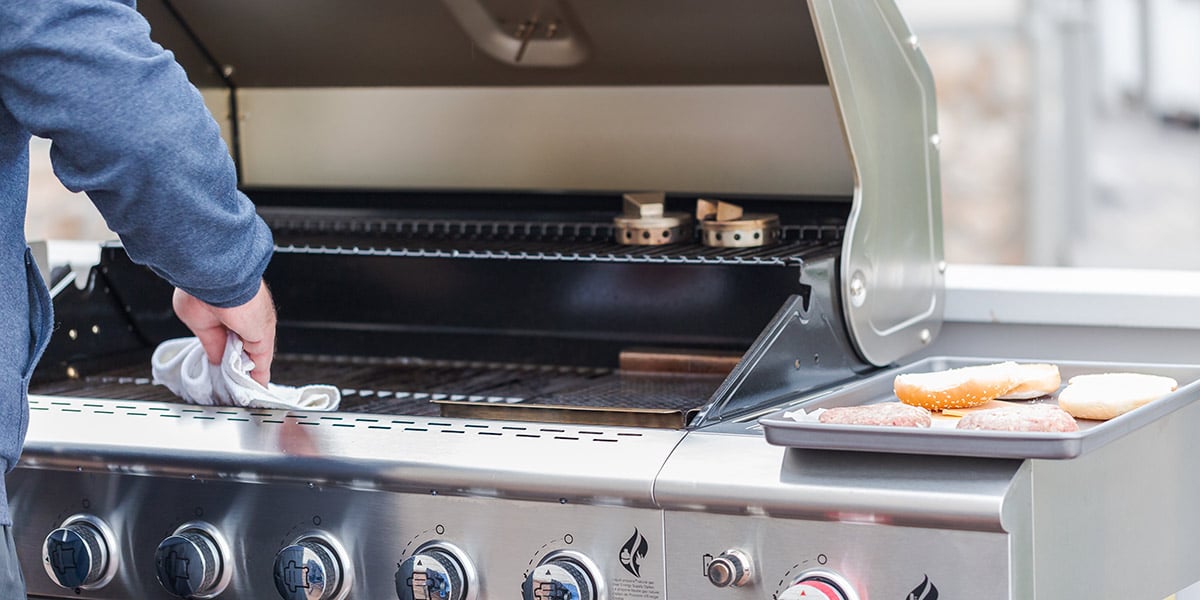 person wiping down grill