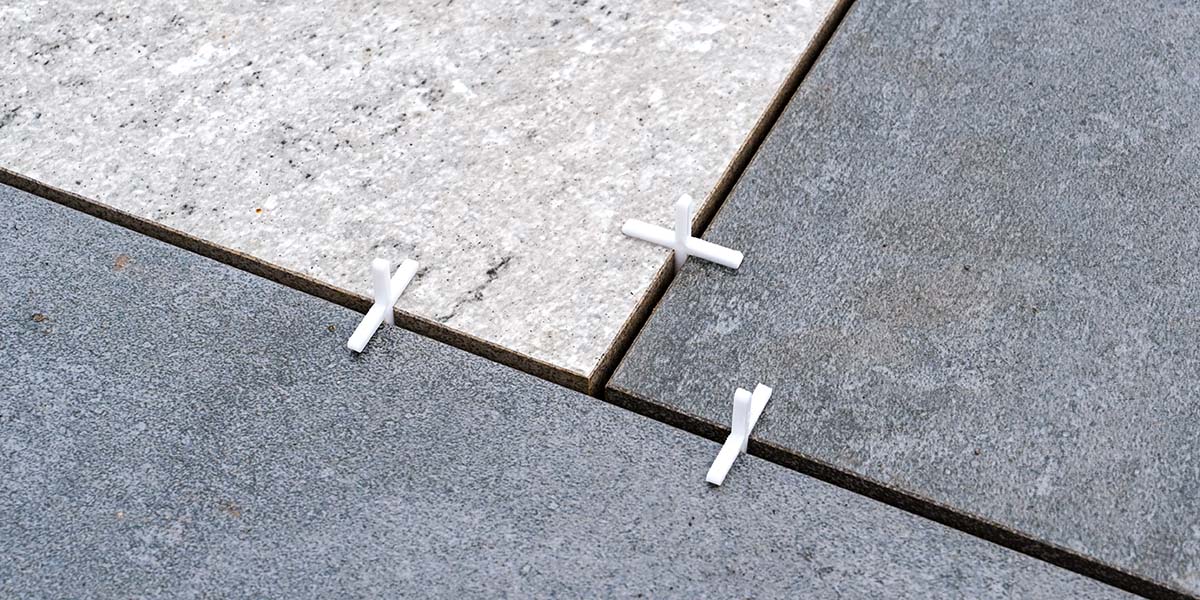 porcelain patio tiles being installed for an outdoor kitchen