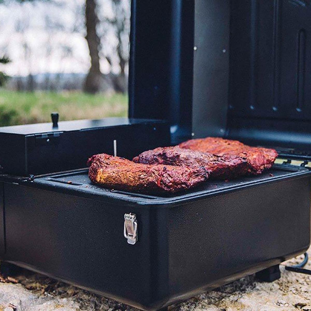 portable traeger grill with steak on it