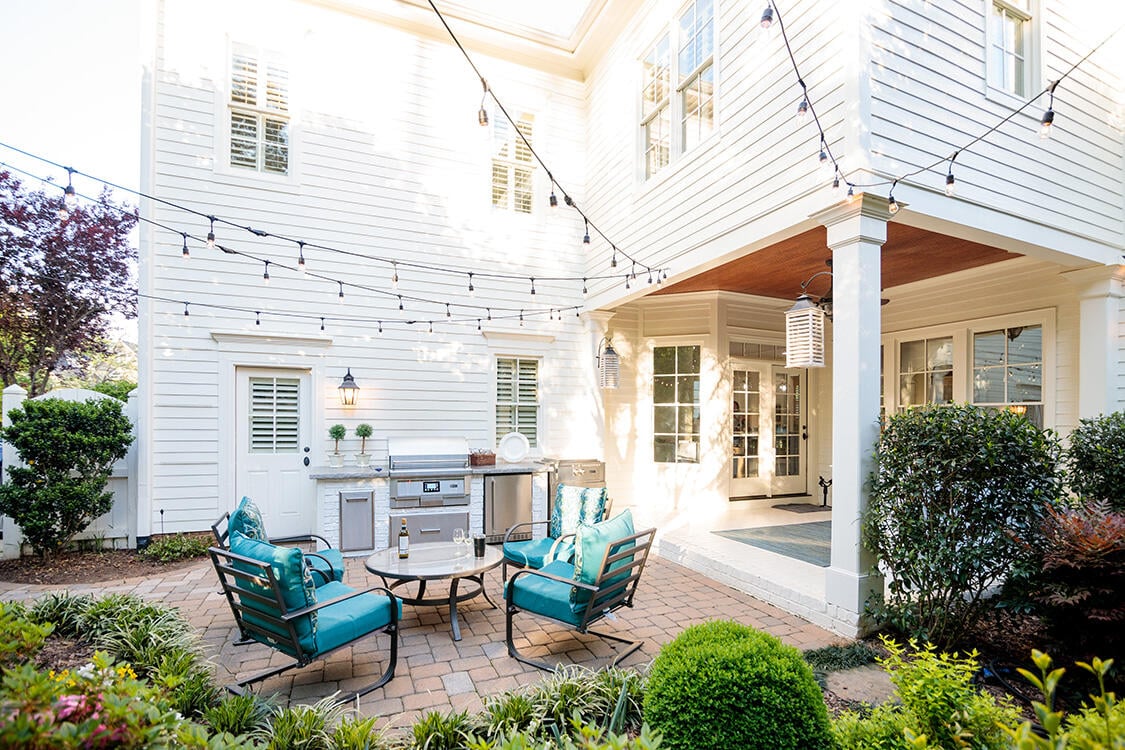 reclaimed brick outdoor kitchen on patio with built in pellet grill and outdoor lighting