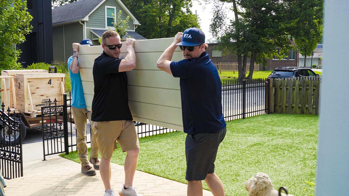 rta employee helping move a panel for outdoor kitchen assembly
