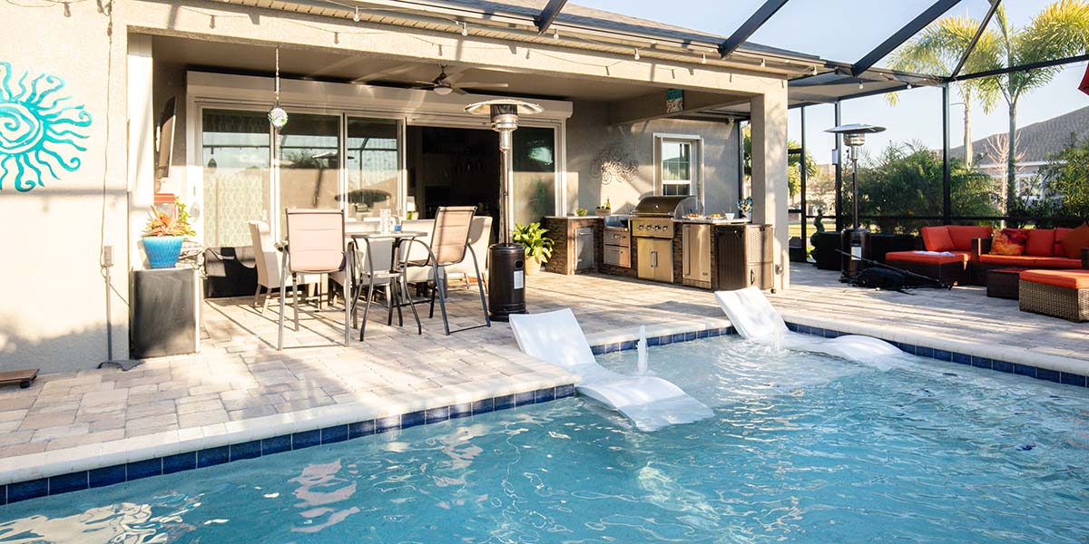 rta outdoor kitchen under structure next to pool and furniture