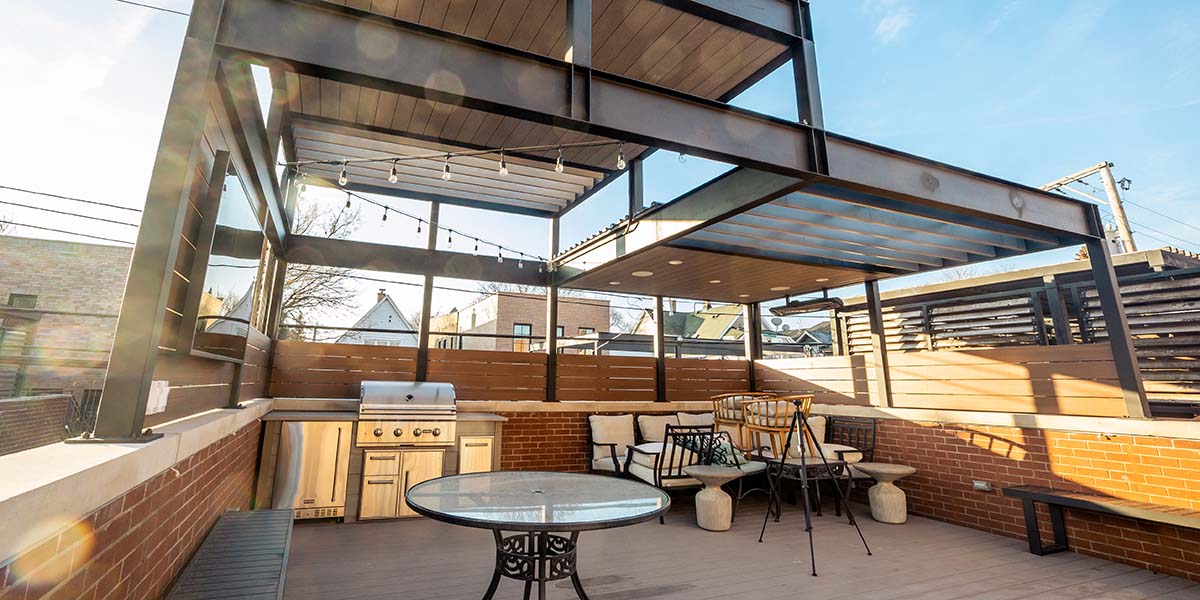 What is a pavilion? rta outdoor kitchen with string lighting under a large pavilion
