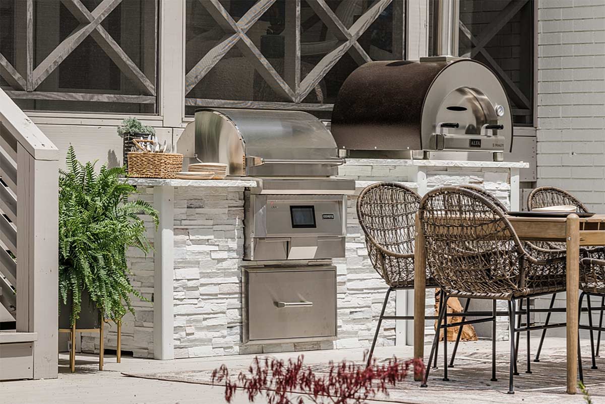 rta pellet grill island with alfa pizza oven in stacked stone chalk on patio