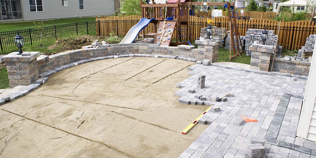 sand base for a paver patio in the backyard being completed