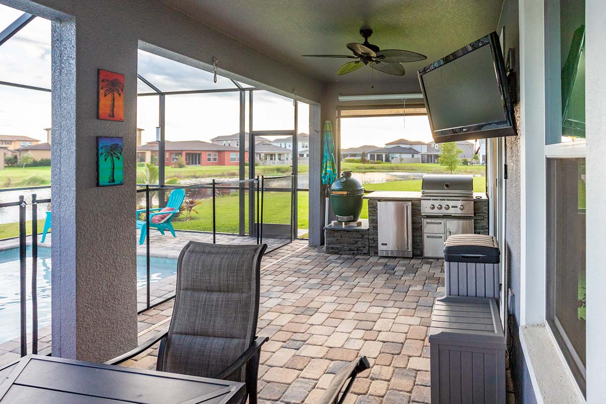 Small linear outdoor kitchen in Florida room next to a pool