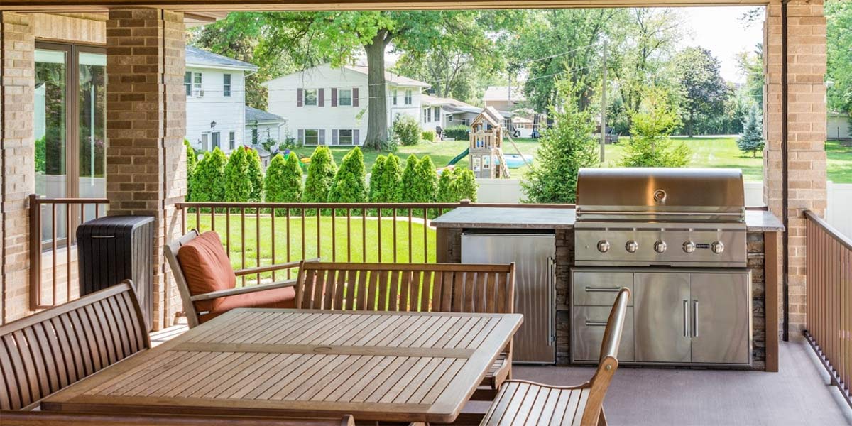 small linear outdoor kitchen on deck overlooking backyard