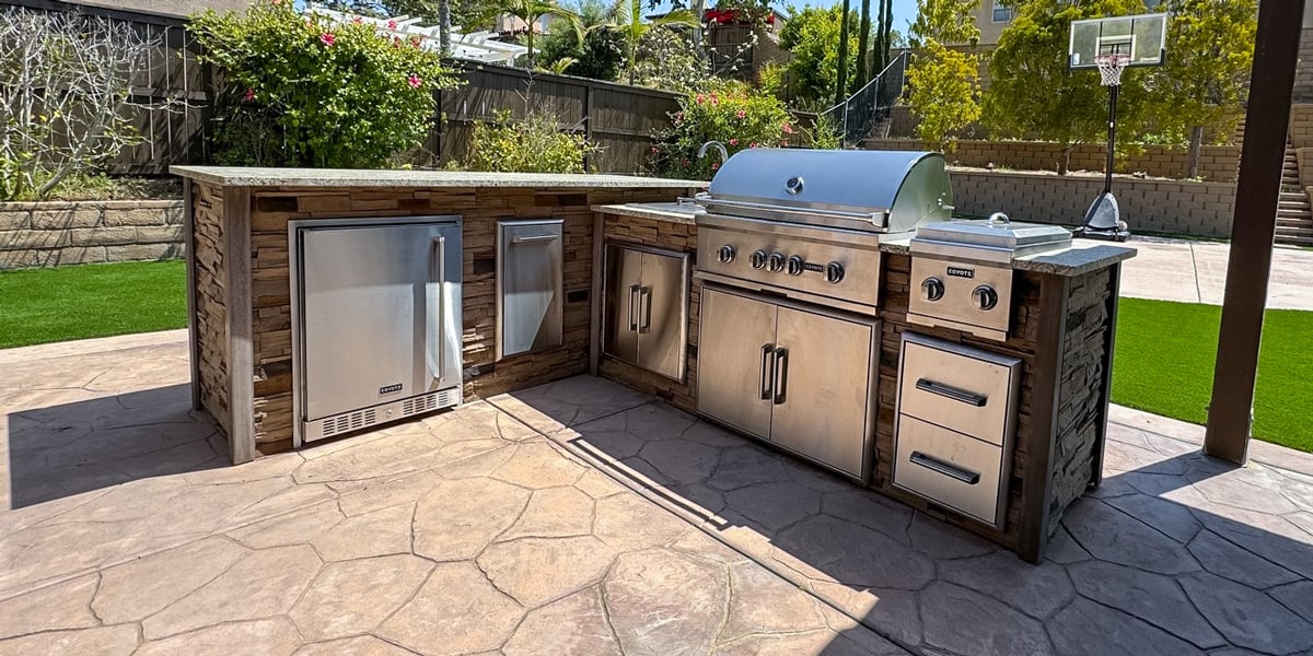 stacked stone l shaped outdoor kitchen idea with outdoor refrigerator