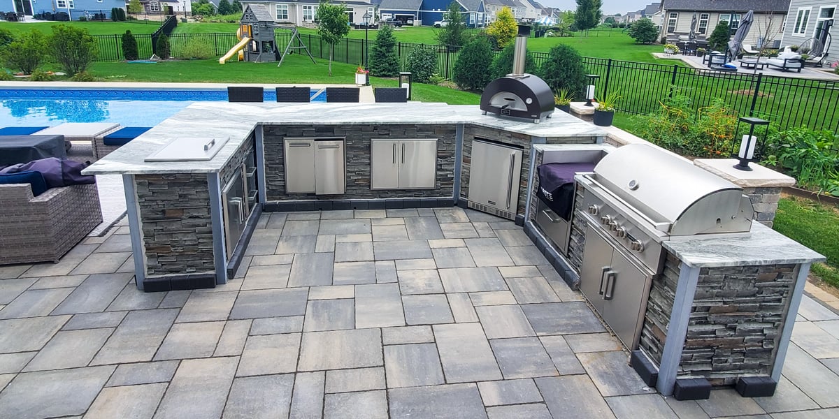 stacked stone outdoor kitchen on paver patio