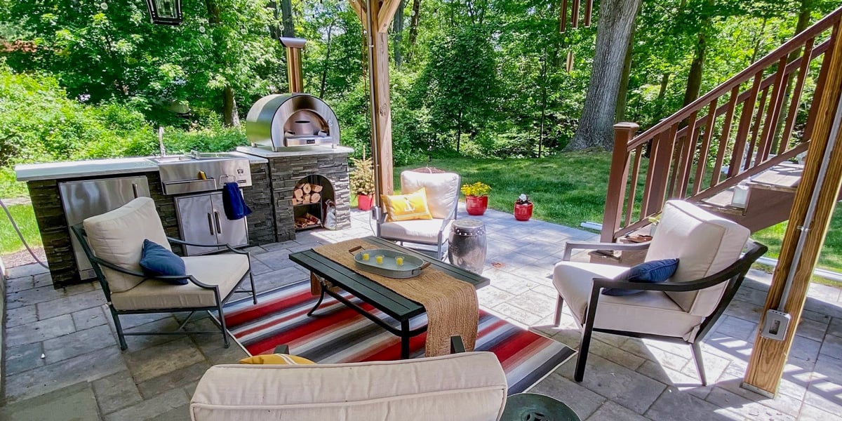 stacked stone outdoor kitchen with pizza oven on patio