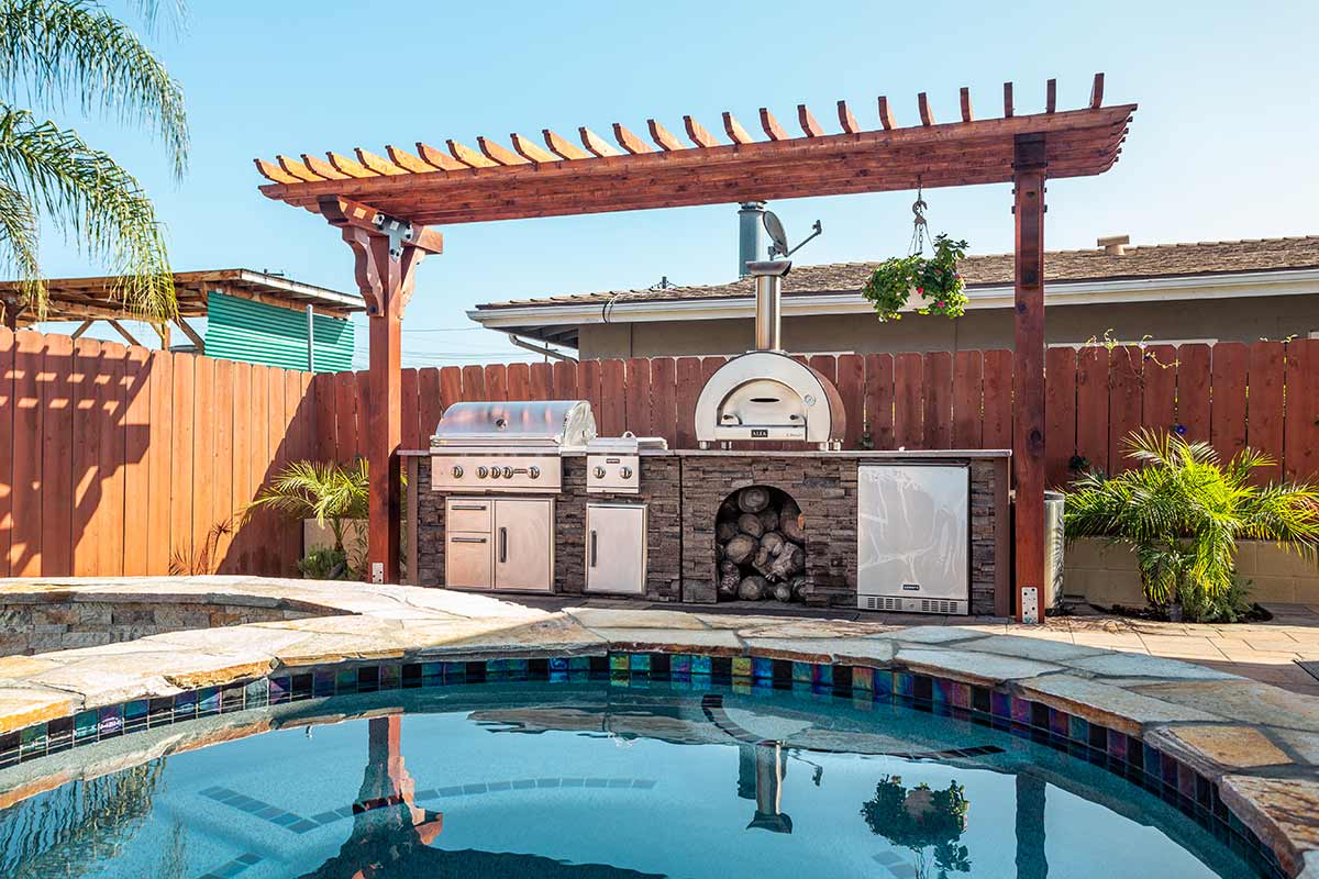 High end diy stacked stone terra linear grill island kit next to pool with pizza own and refrigerator