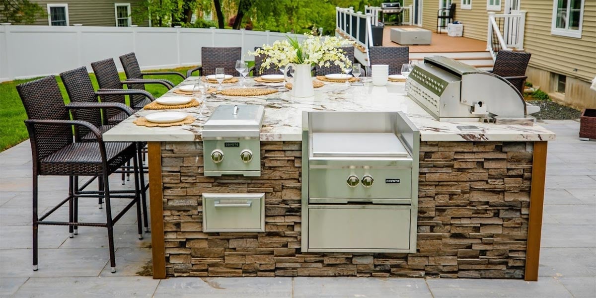 backyard stone outdoor kitchen idea with power burner and dining area